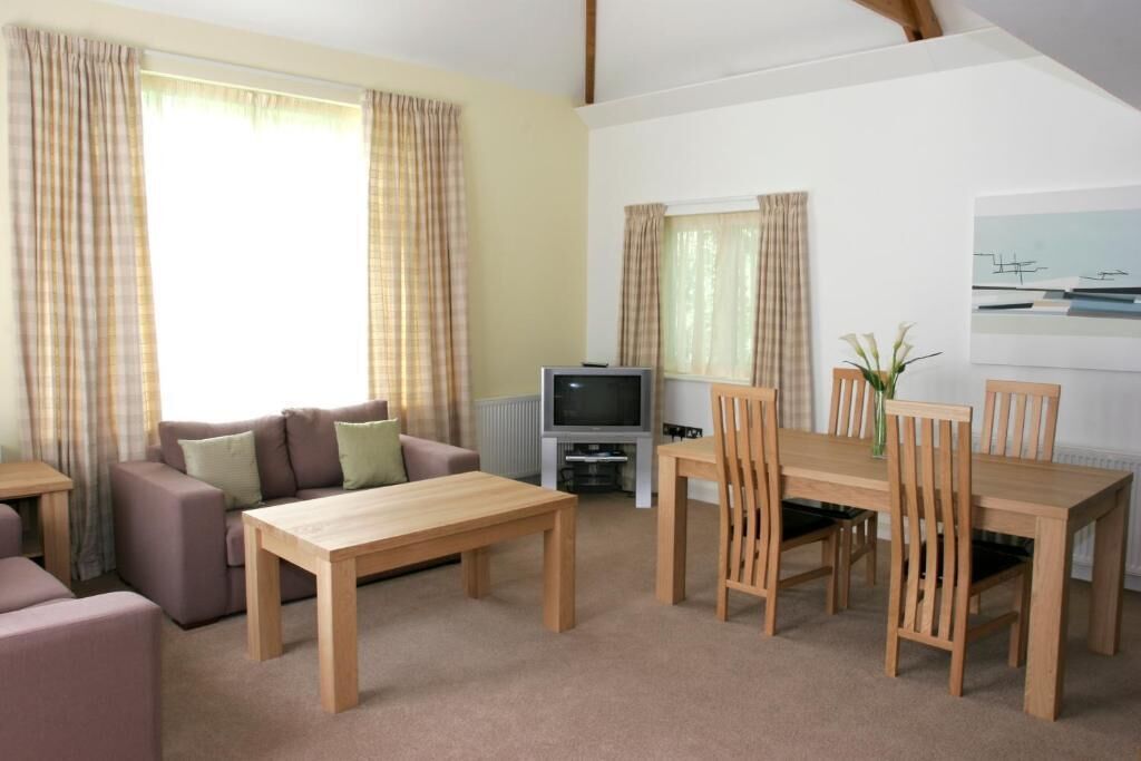 A living room with a sofa, a wooden table, and a TV.