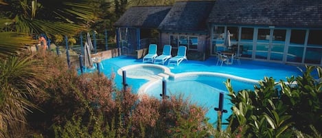Inomhuspool, en säsongsöppen utomhuspool, parasoller och solstolar
