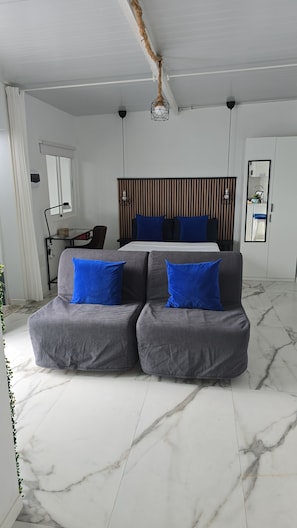 Un dormitorio moderno con cama, escritorio y sofá.