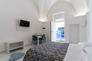 A modern hotel room with a bed, a desk, and a TV mounted on the wall. - 3560 Le Suite di Chiara -orchidee by Barbarhouse (Porto Cesareo)