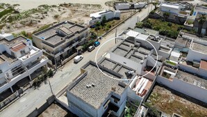 Vista aérea de una zona residencial costera con edificios, carreteras y una playa.