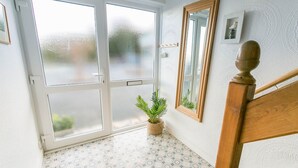 A room with a wooden staircase, a potted plant, and a large mirror on the wall. - Pencoed -  a coastal that sleeps 5 guests  in 3 bedrooms (Llanbedrog)