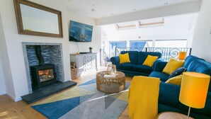 Un salon moderne avec une cheminée, un ensemble de canapés et un balcon offrant une vue agréable.