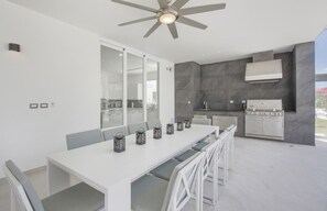 A modern kitchen with a built-in stove and a ceiling fan. - Palmas 15: Luxury villa w/ mosquito net, lap-pool, Jacuzzi, staff & golf cart (Punta Cana)