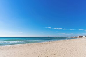 A wide sandy beach with clear blue water and a distant shoreline. - 3563 Villa del Bacino - App Rosso by Barbarhouse (Porto Cesareo)