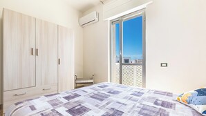 A bedroom with a bed, a wardrobe, an air conditioning unit, and a view of the outside. - 3564 Villa del Bacino - App Blu by Barbarhouse (Porto Cesareo)
