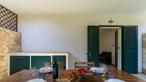 A dining table set with plates, cutlery, a bottle, and a bowl of food. - 3441 Villa Selvaggia by Barbarhouse (Nardò)