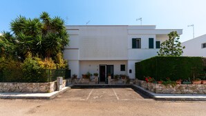 A modern building with a flat roof, a central entrance, and a paved driveway. - 3441 Villa Selvaggia by Barbarhouse (Nardò)