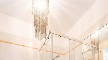 Un bagno moderno con doccia vetrata, lavandino bianco e water.