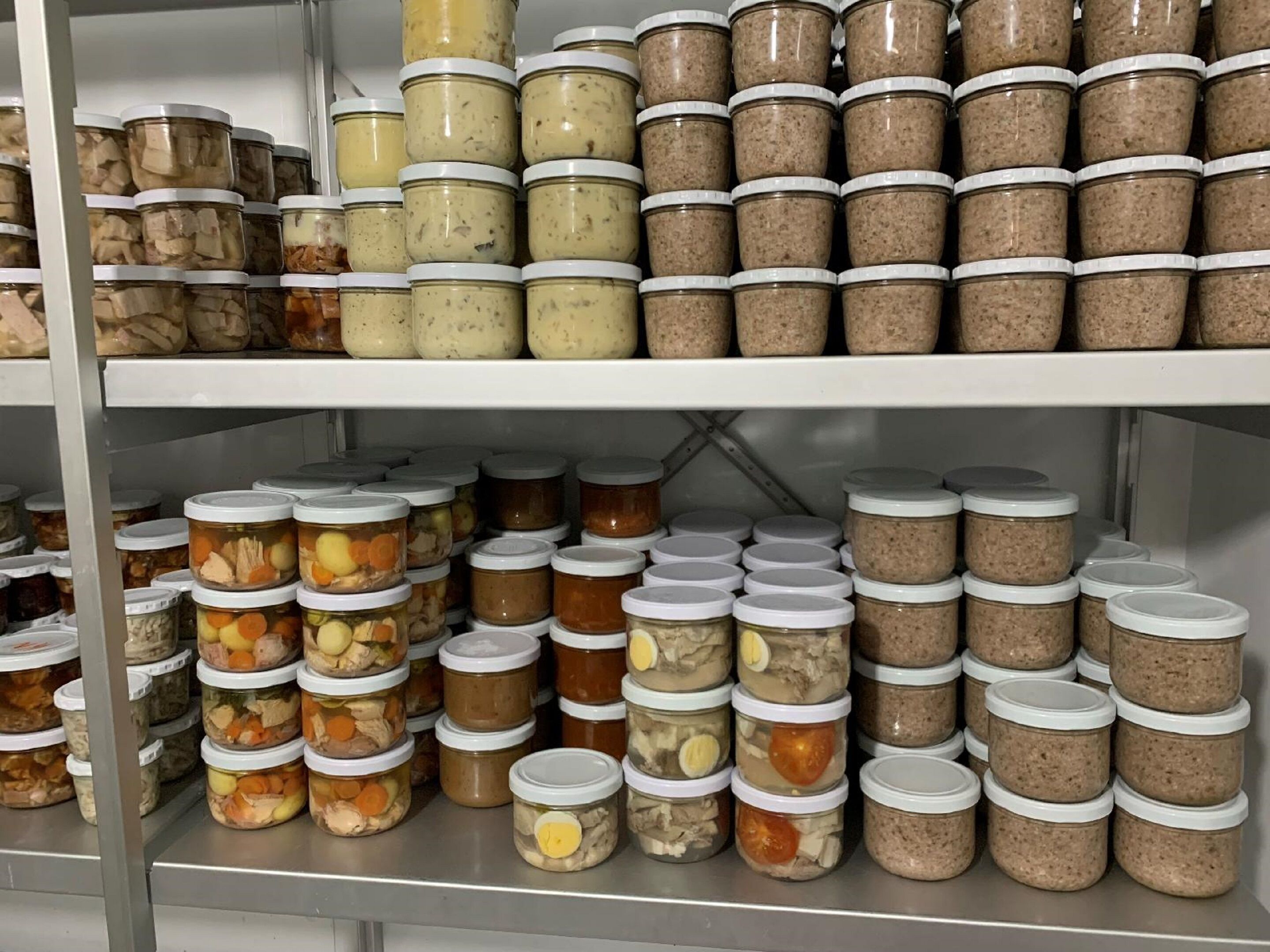 A storage area with multiple shelves filled with jars of preserved food items.