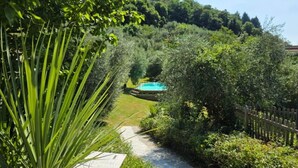 A pathway leading to a pool surrounded by lush greenery and a wooden fence. - Shaleo, Private Pool & Jacuzzi, Marliana (Marliana)