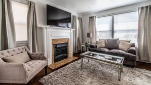 A living room with a fireplace, a television, a sofa, and a coffee table.