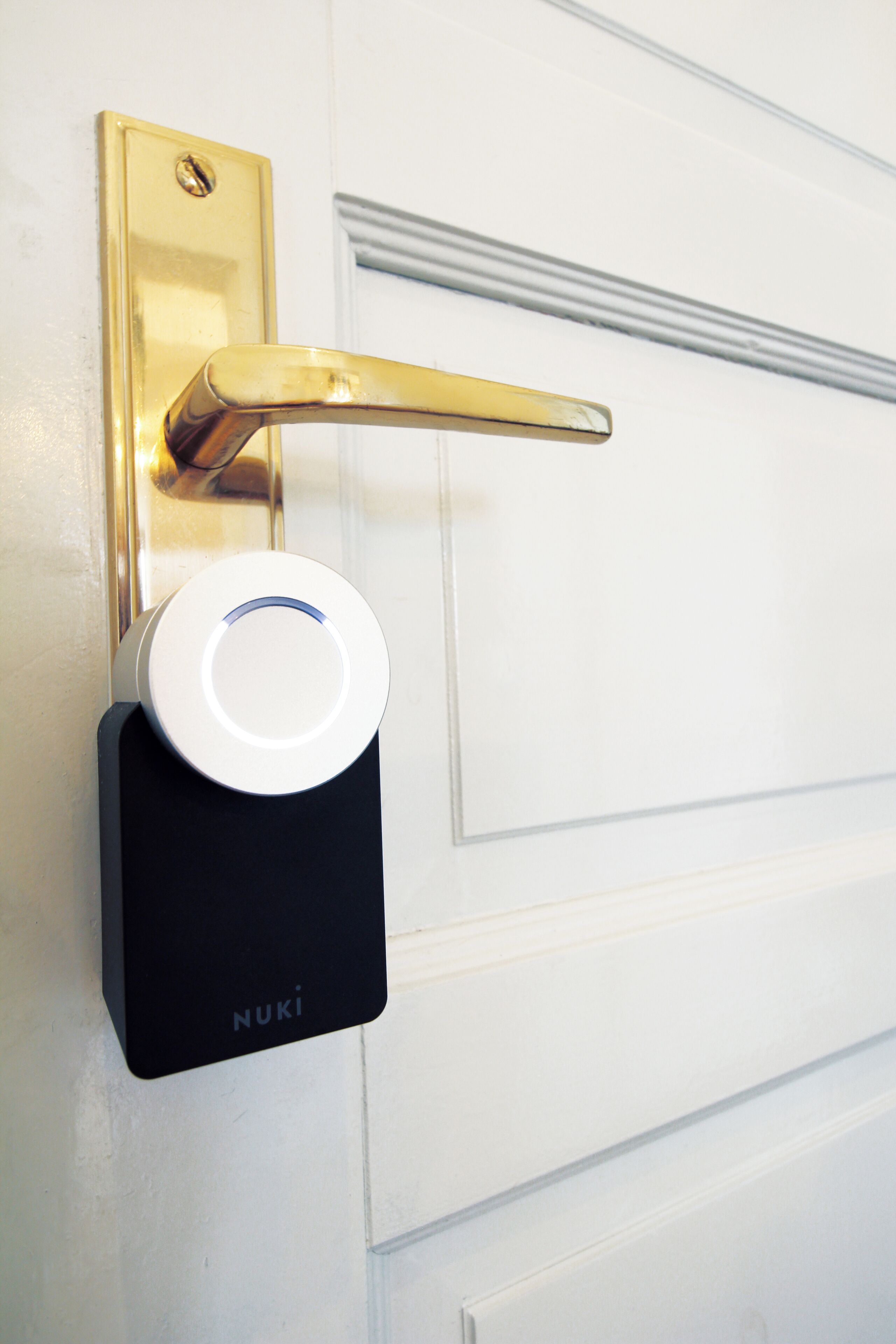 A door with a gold handle and a white electronic lock labeled "NUKI".