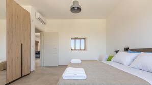 Ein modernes Schlafzimmer mit einem großen Bett, einem Kleiderschrank und einem Fenster.