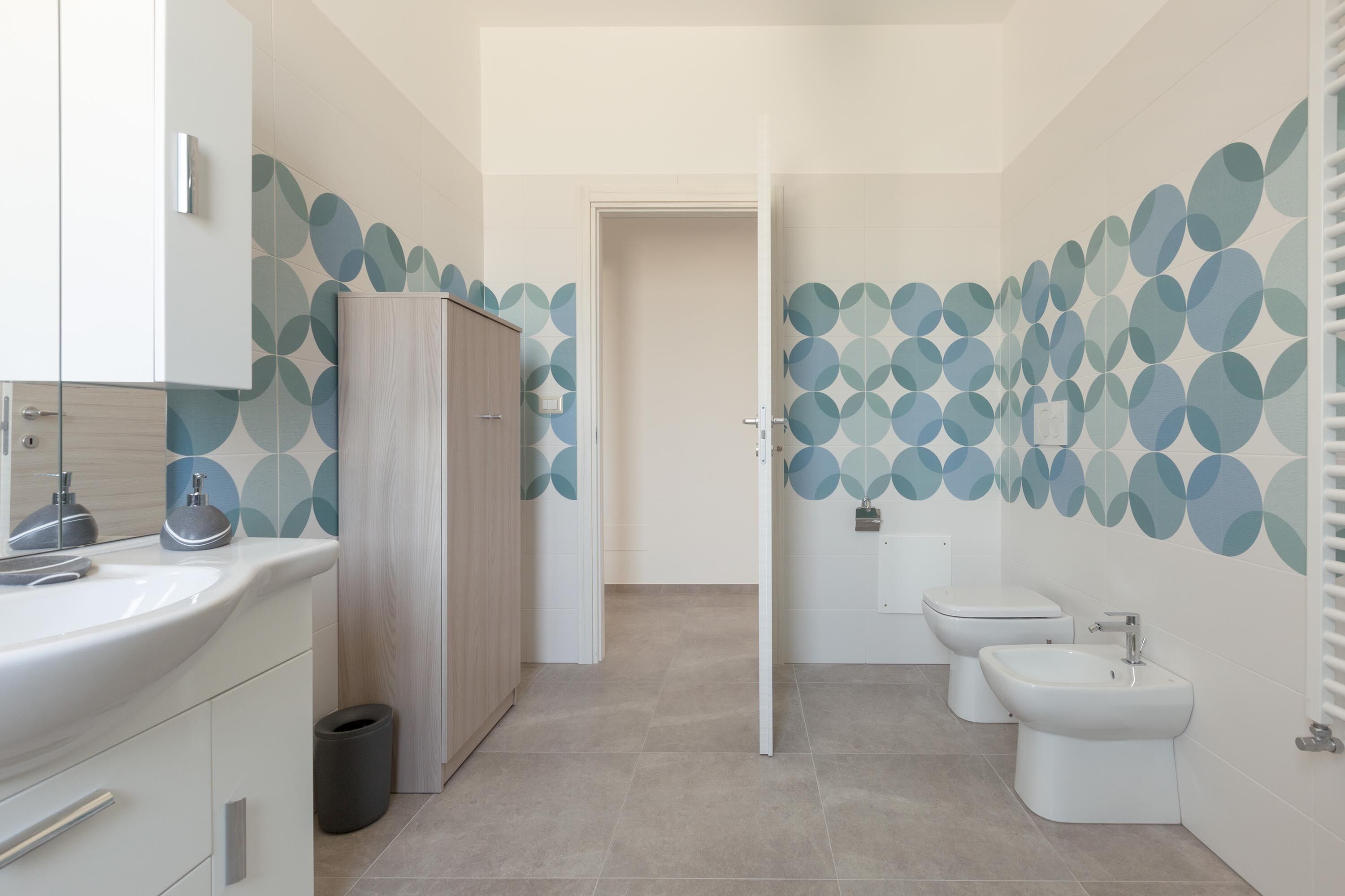 Ein modernes Badezimmer mit Waschbecken, Schrank, Bidet und Toilette.