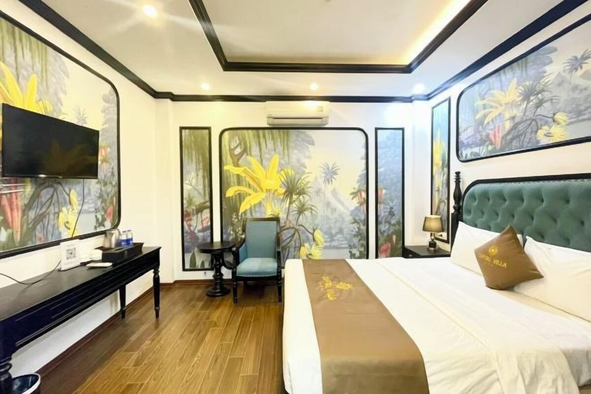 A hotel room with a bed, a TV, a desk, and a chair.