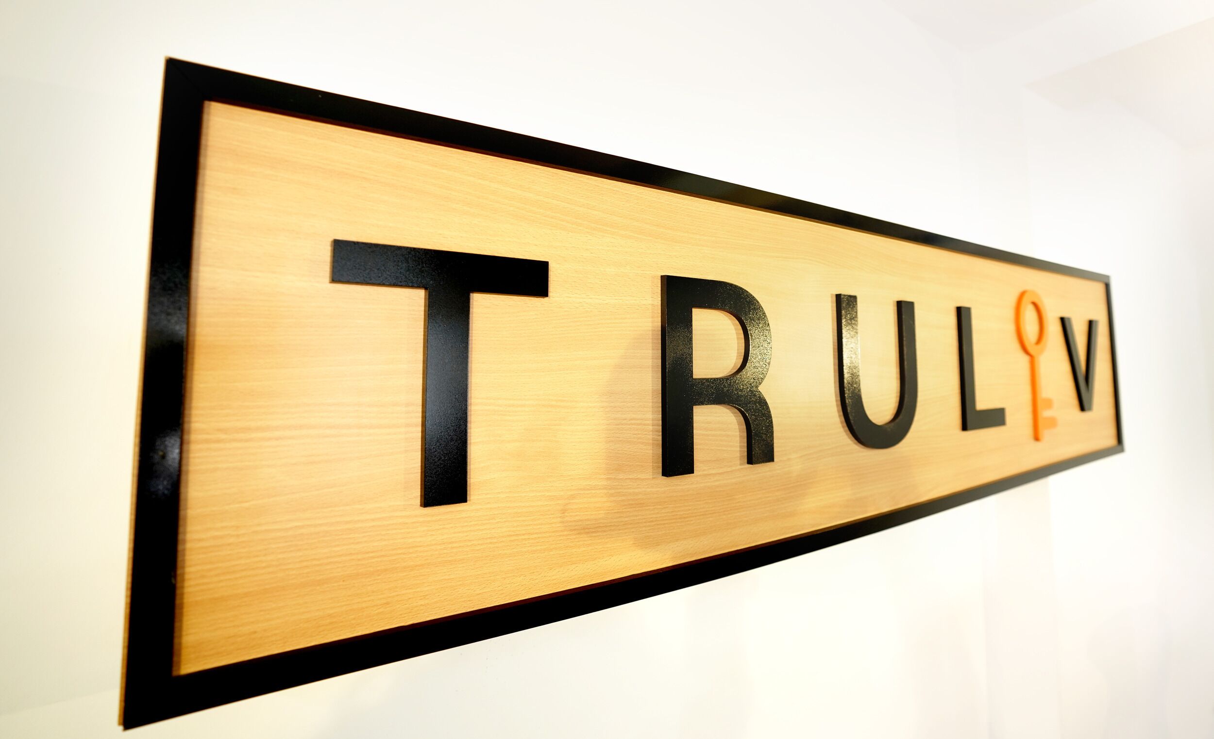 A wooden sign with the letters "TRULW" and a key symbol.
