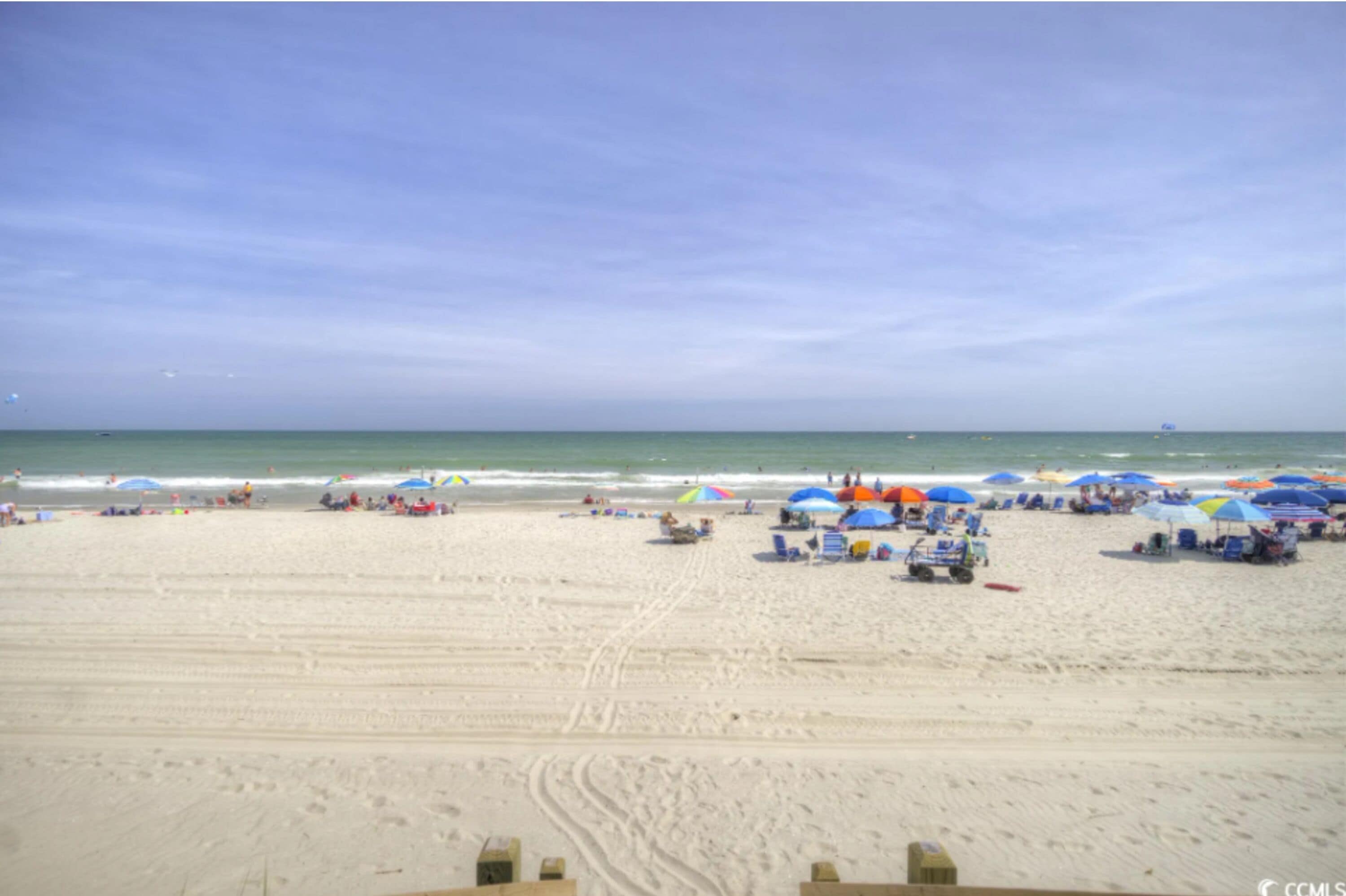 Uma praia com guarda-sóis e cadeiras de praia.