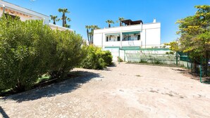 A residential area with a white building featuring a balcony and a paved courtyard. - 3447 Villetta Grazia by Barbarhouse (Nardò)