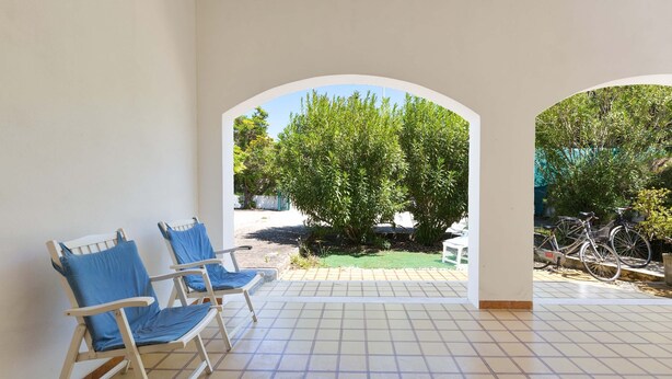 A covered patio area with tiled flooring and two blue cushioned chairs. - 3447 Villetta Grazia by Barbarhouse (Nardò)