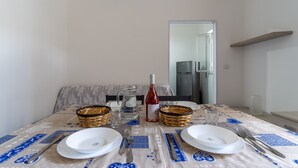 A dining table set with plates, cutlery, a wine bottle, and baskets. - 3463 Villetta Naomi by Barbarhouse (Porto Cesareo)
