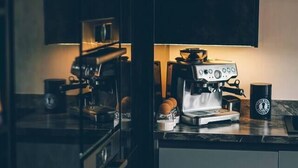 A modern kitchen with a coffee machine, a cup, and a plant. - The Longsands Home • Coastal w/ Hot Tub (Tynemouth)