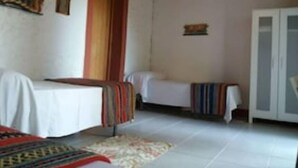 Una habitació amb dos llits, un armari i una catifes petita.