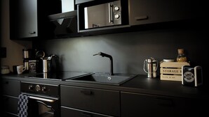 Une cuisine moderne dotée d’appareils électroménagers en acier inoxydable, d’un évier et d’une boîte de rangement étiquetée « BOÎTE DE RANGEMENT ».