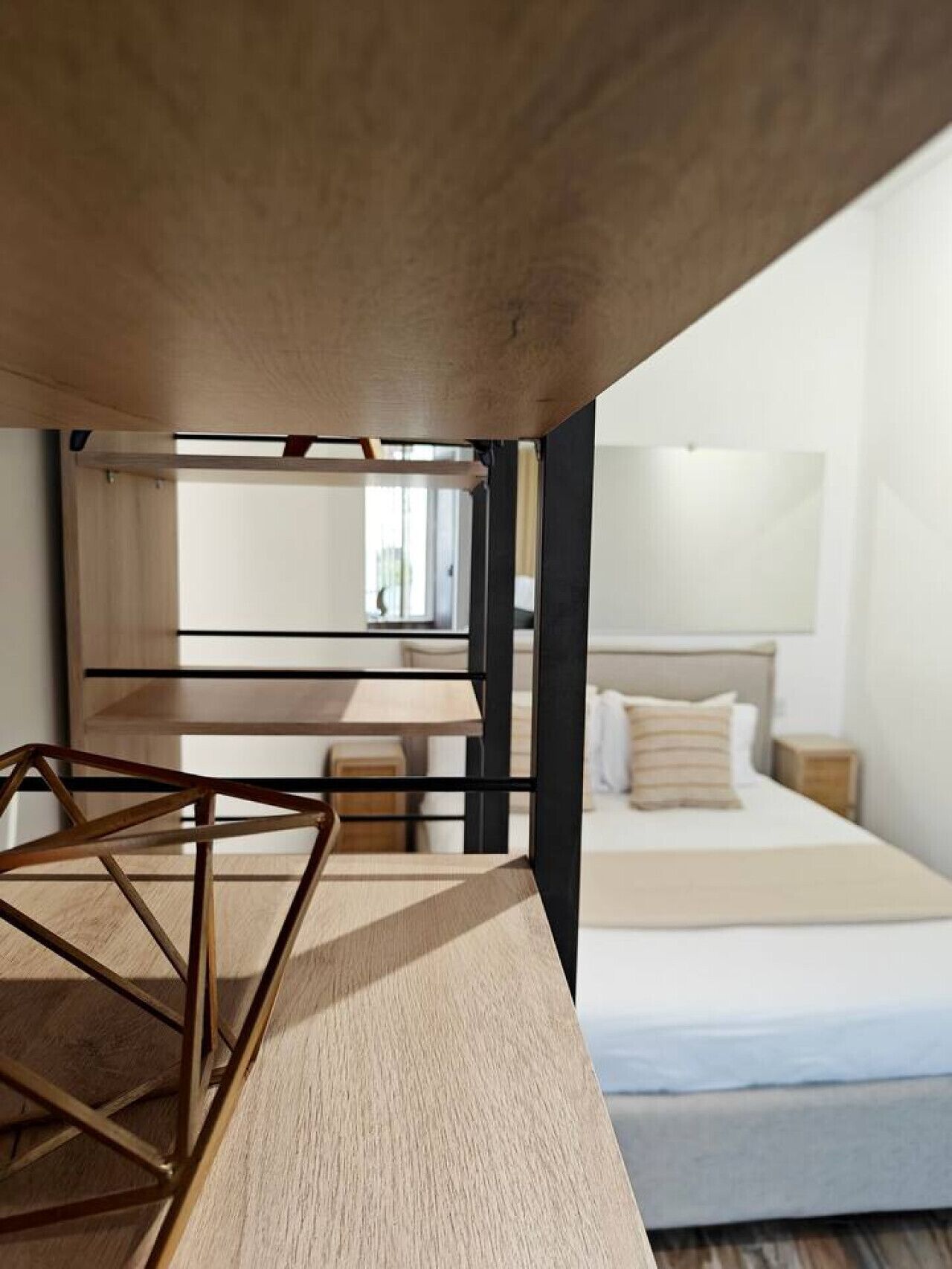 Una camera da letto con un letto a castello, una scrivania in legno e una finestra.