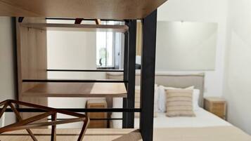 Una camera da letto con un letto a castello, una scrivania in legno e una finestra.