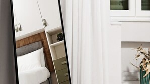 Un dormitorio con una cama, un tocador y un espejo.