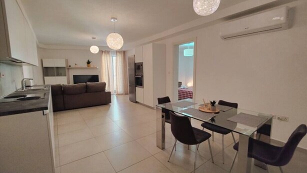 Eine moderne Wohnung mit Küche, Essbereich und Wohnzimmer.