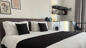 A hotel room with a large bed, a washing machine, and a chair. - The Valley Room 6 with parking on premises (San Ġiljan)