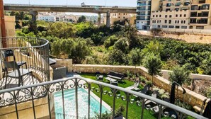A rooftop garden with a swimming pool, outdoor seating, and a view of a bridge and buildings. - The Valley Room 6 with parking on premises (San Ġiljan)