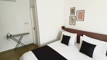 Une chambre d’hôtel avec un lit, un téléviseur à écran plat, une petite table et une porte.