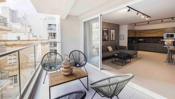 Een modern appartement met balkon, een eethoek en een keuken.
