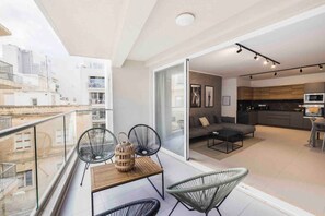 A modern apartment with a balcony, a dining area, and a kitchen. - The Ultimate escape-3 bedroom apartment (Tas-Sliema)