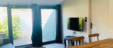 Ein modernes Wohnzimmer mit einem Holzespeisetisch, einer Couch und einem großen Fenster.
