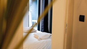 A hotel room with a bed, a window, and a door. - Bel Air, Accès Piscine - Jacuzzi Privé - Terrasse (Criel-sur-Mer)