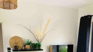 A dining area with a table, chairs, and a television mounted on the wall. - Appartement - Piscine - Terrasse, Beau Séjour (Criel-sur-Mer)
