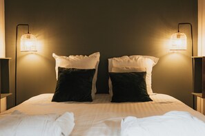 A neatly made bed with two pillows, two wall-mounted lamps, and a plain wall. - Appartement - Piscine - Terrasse, Beau Séjour (Criel-sur-Mer)