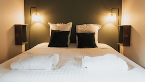 A neatly made bed with white linens and two black pillows, flanked by wall-mounted lamps. - Appartement - Piscine - Terrasse, Beau Séjour (Criel-sur-Mer)