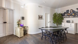 Una cocina moderna con una isla grande, muebles blancos y un cuadro de un paisaje urbano en la pared.