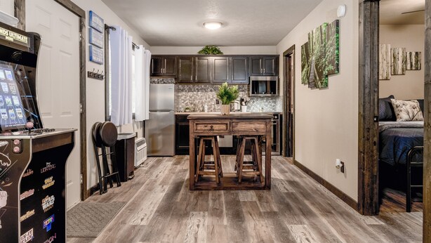 Una cocina compacta con armarios de madera, una isla central y un refrigerador pequeño.