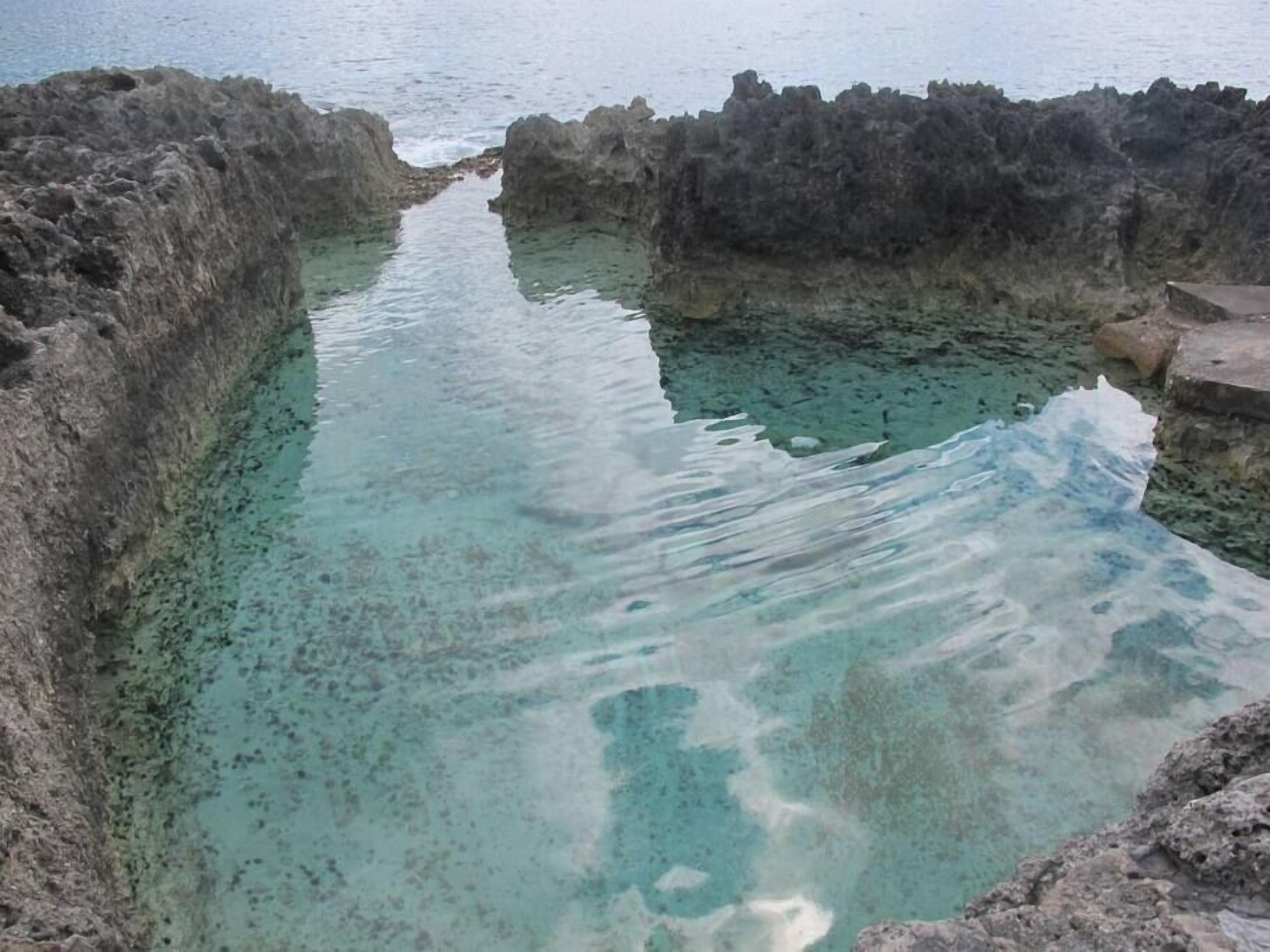 A natural pool surrounded by rocky terrain.