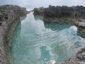 A natural pool surrounded by rocky terrain. - Fabulous one Bedroom in West Bay (West Bay)