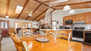 A spacious kitchen with wooden cabinets, a central island, and a dining area with a wooden table and chairs.