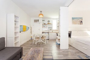 A compact living space with a kitchenette, dining area, and a bedroom. - Beach Shack Fremantle (Fremantle)
