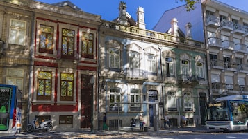 Um edifício histórico com arquitetura clássica, incluindo janelas e varandas ornamentadas.