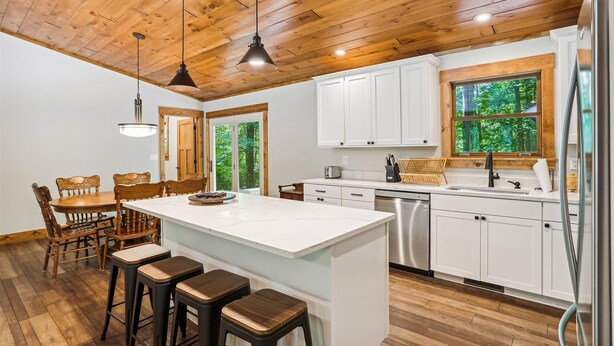 A modern kitchen with white cabinets, a wooden ceiling, and a large window overlooking greenery. - Blueberry: 3  BR, 3  BA House in Canaan Valley, Sleeps 6 (Canaan Valley)